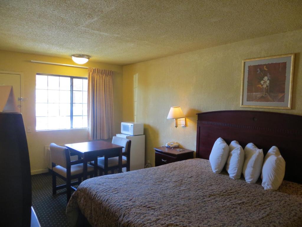 a hotel room with a bed and a desk at Welcome Inn in Dallas