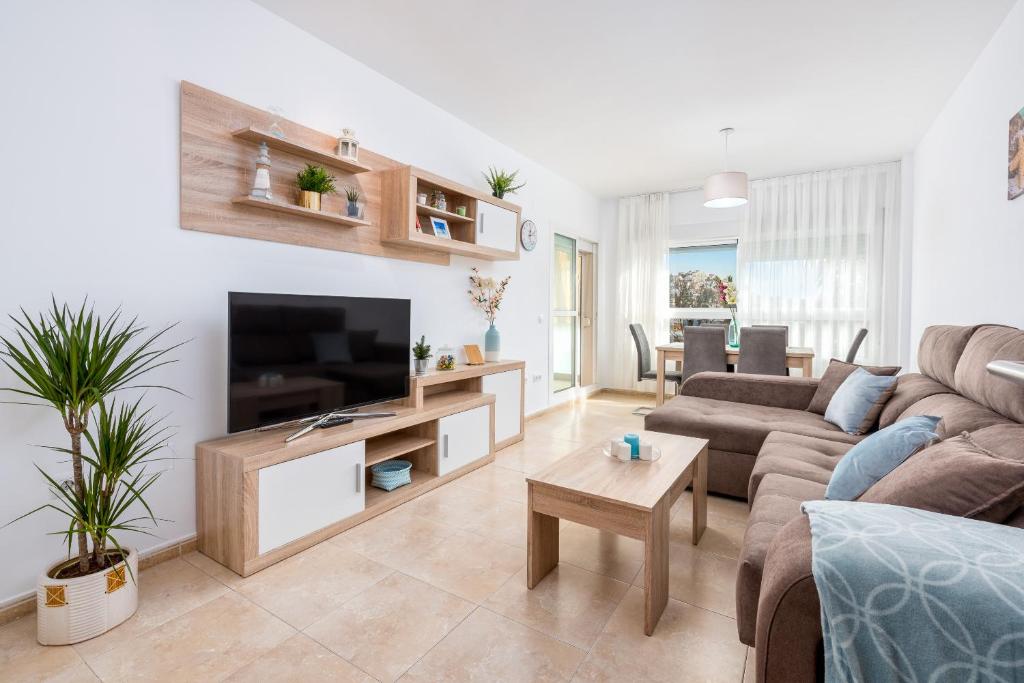 ein Wohnzimmer mit einem Sofa und einem Flachbild-TV in der Unterkunft WintowinRentals Best Location, Beach, Pool & Parking in Rincón de la Victoria