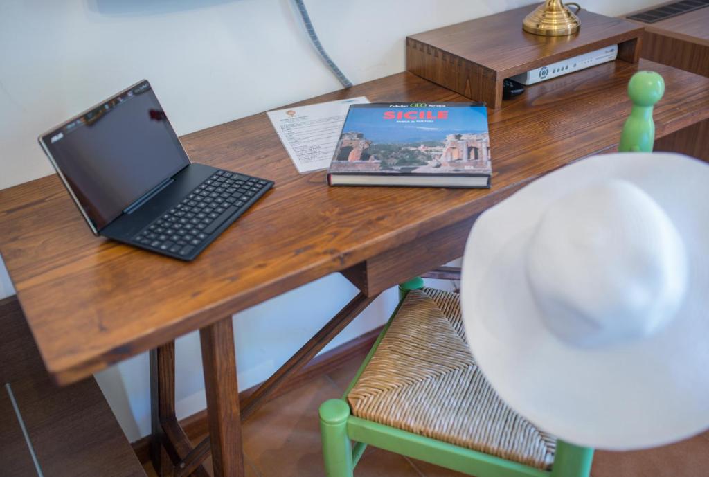 a wooden table with a laptop computer on top of it at Hotel Villa Sirina in Taormina