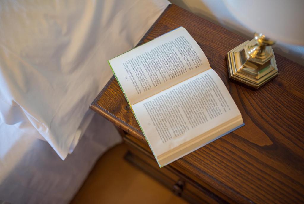 a book sitting on a table next to a bed at Hotel Villa Sirina in Taormina