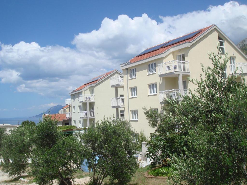 a large building with trees in front of it at Apartments Ivana in Baška Voda