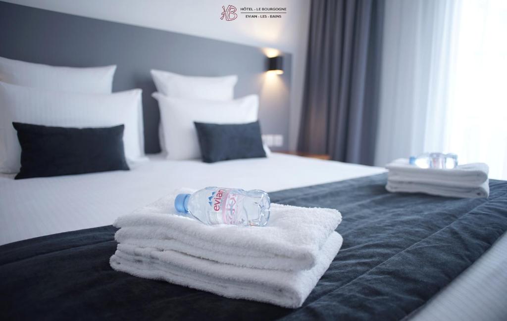 a pile of towels sitting on top of a bed at Hotel Le Bourgogne in Évian-les-Bains