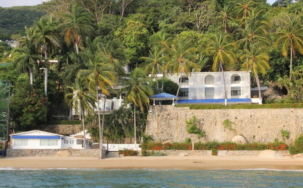 a house on the beach with palm trees at Maravillosa casa con 7 habitaciones, acceso directo a playa pichilingue, bahía de puerto marqués, zona diamante Acapulco in Acapulco