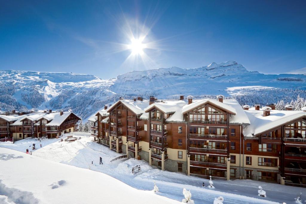 um hotel na neve com montanhas ao fundo em residence les Terrasses d'Eos - maeva Home em Flaine