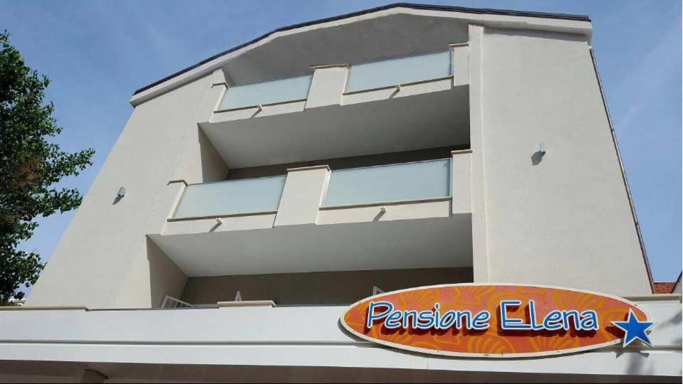 ein weißes Gebäude mit einem Schild davor in der Unterkunft Pensione Elena in Misano Adriatico