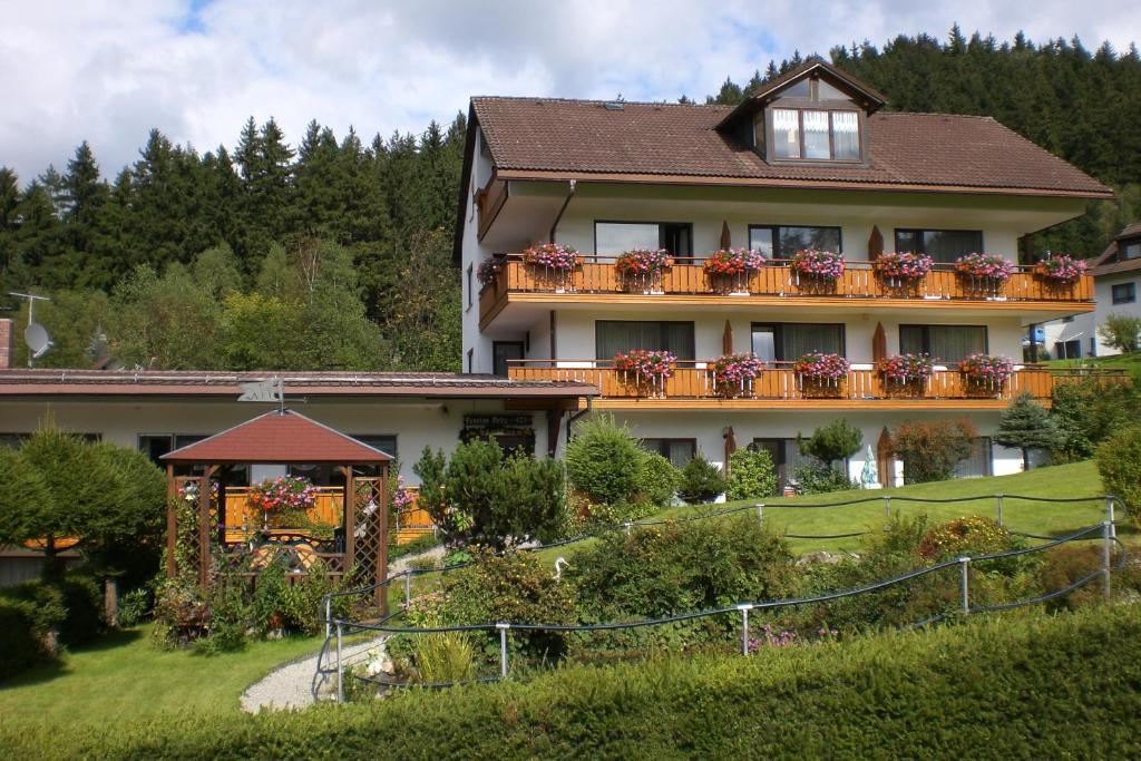 a large house with a balcony with flowers on it at Pension Brix in Warmensteinach