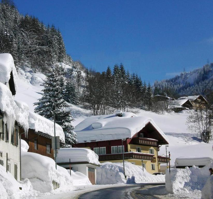 un edificio coperto di neve vicino a una strada di Haus Christian a Klösterle am Arlberg