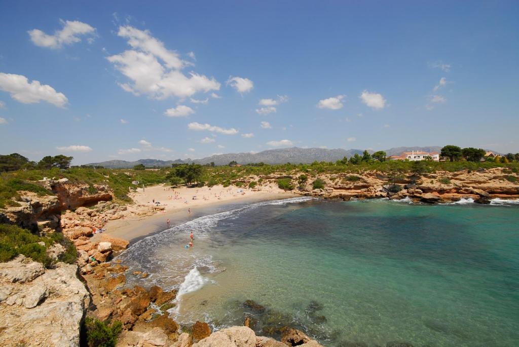 a beach with a group of people in the water at Duplex Ancla in L'Ametlla de Mar