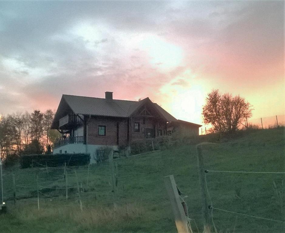 a house on a hill with the sunset in the background at FeWO Koeppe in Kopp