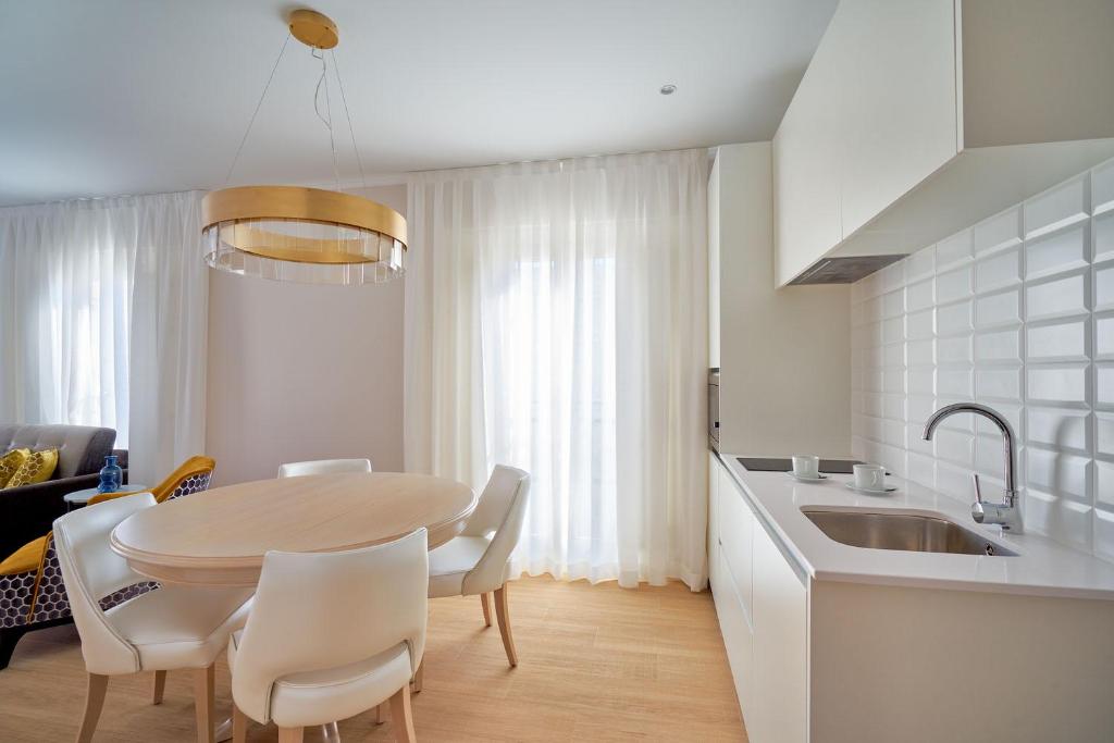 a kitchen and dining room with a table and chairs at Tandem Soho Suites in Málaga
