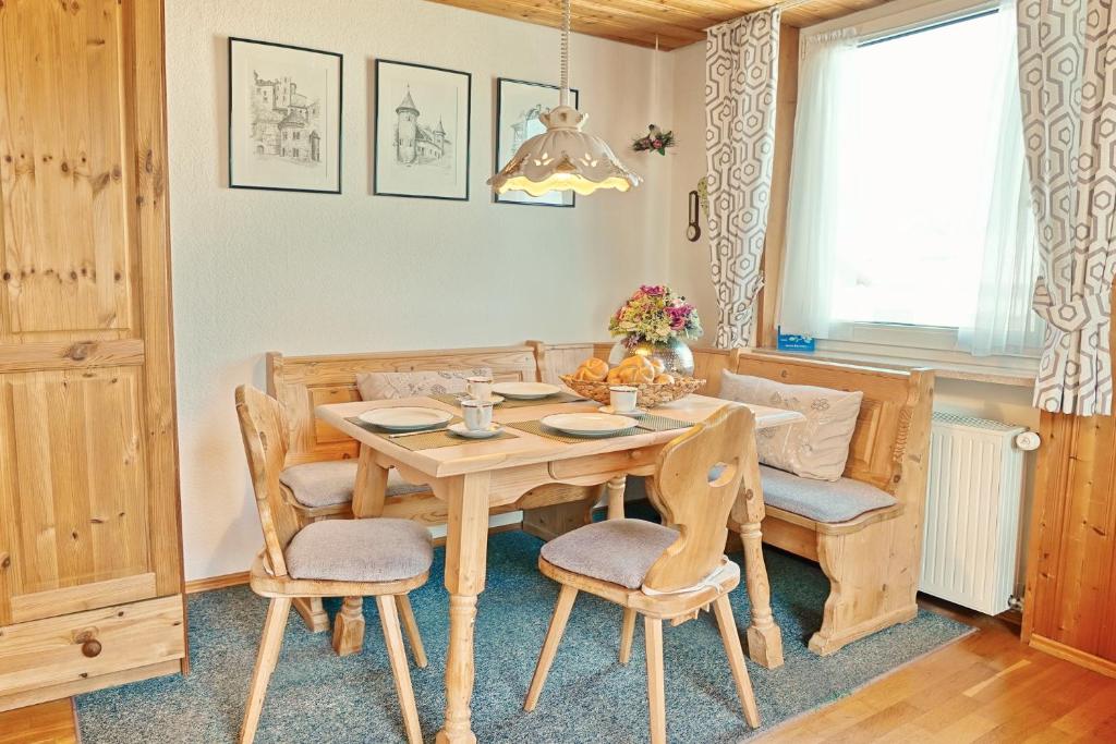 - une salle à manger avec une table et des chaises en bois dans l'établissement Bergblick, à Fischen im Allgäu
