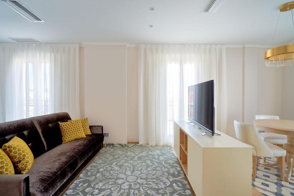 a living room with a couch and a television at Tandem Soho Suites in Málaga