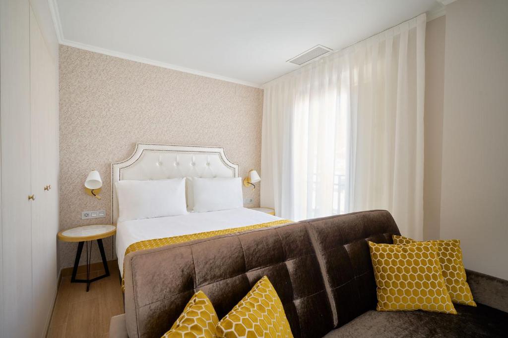 a hotel room with a bed and a couch at Tandem Soho Suites in Málaga