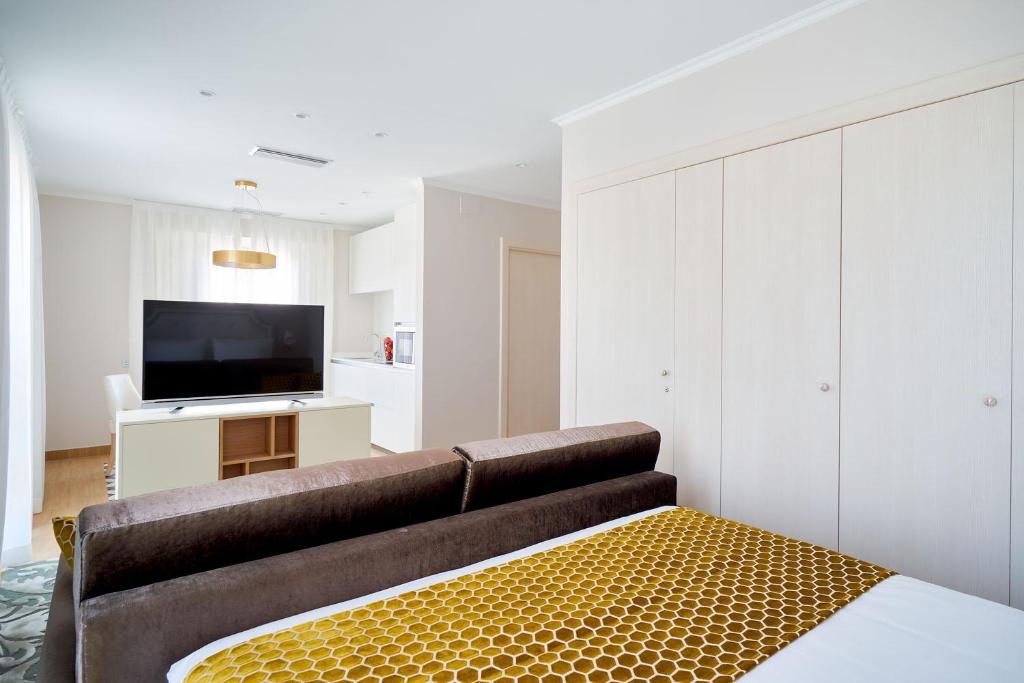 a living room with a couch and a flat screen tv at Tandem Soho Suites in Málaga