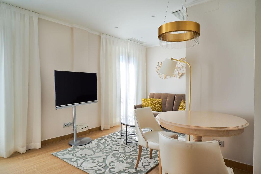 a living room with a table and a tv at Tandem Soho Suites in Málaga
