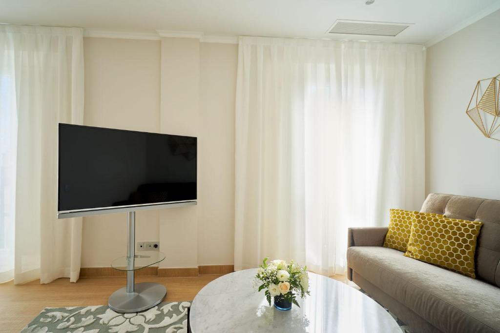 a living room with a large flat screen tv at Tandem Soho Suites in Málaga