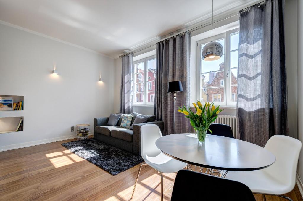 a living room with a table and a couch at Stylish Apartment in Heart of Oldtown in Gdańsk
