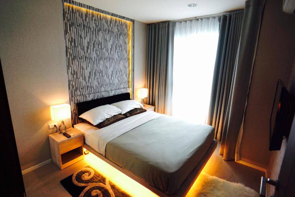 a bedroom with a bed and a large window at Luxury Apartment near Downtown (Pick-up Service) in Bangkok