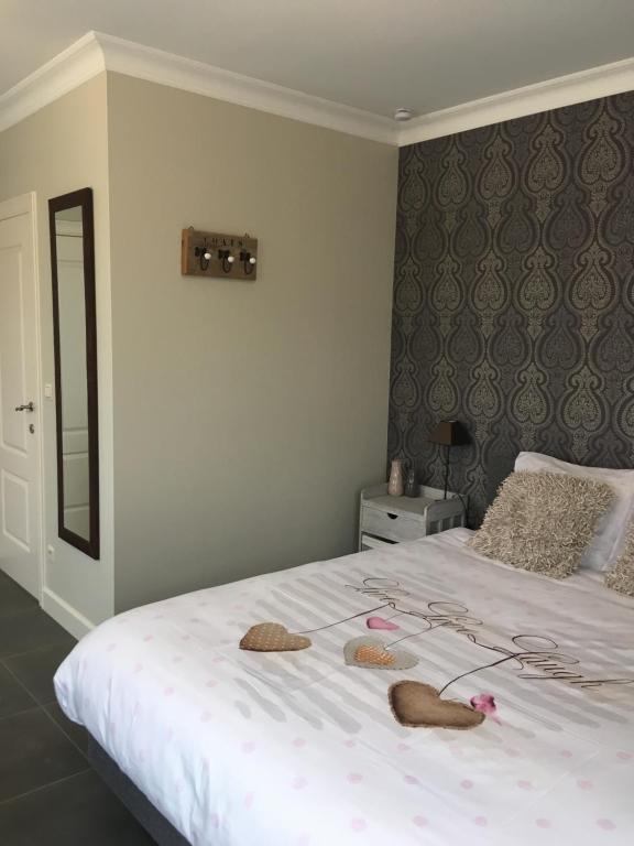 a bedroom with a white bed with two hats on it at Guesthouse De Middelvelden in Arendonk