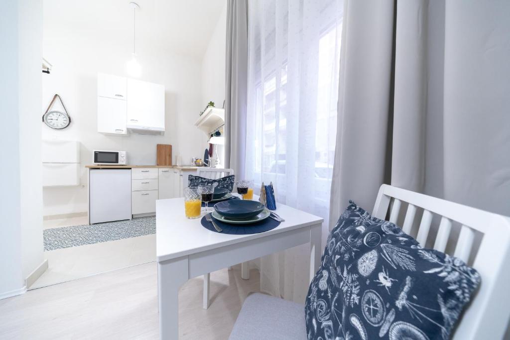 a white kitchen with a table with a plate on it at Deluxe Apartment Portić, self check-in in Zadar