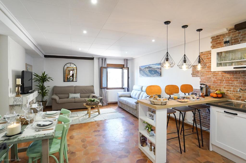 eine Küche und ein Wohnzimmer mit einer Couch und einem Tisch in der Unterkunft Apartamento LA CATEDRAL CUENCA in Cuenca