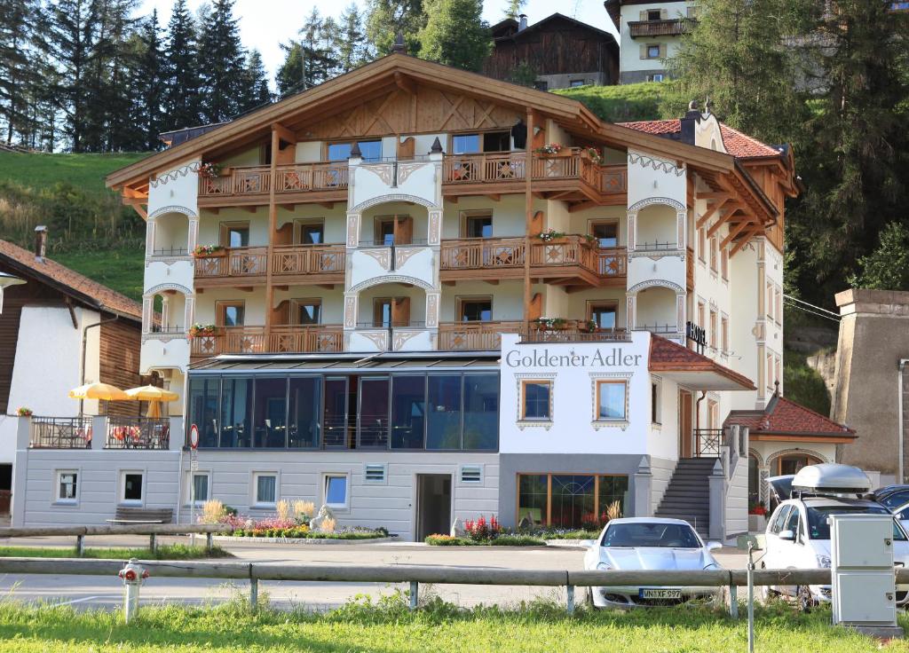 a large building with a balcony on top of it at Hotel Goldener Adler in Curon Venosta