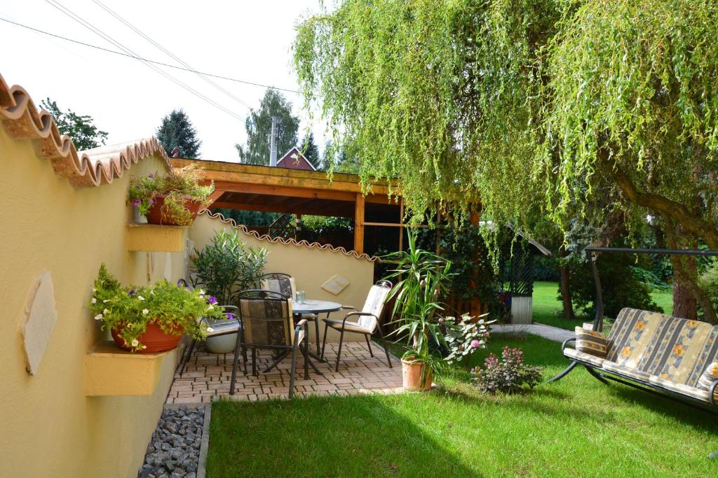 een patio met een tafel en stoelen in een tuin bij Ferienwohnung Arnold in Stolpen