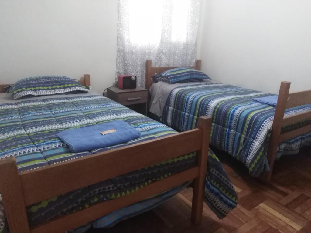 dos camas sentadas una al lado de la otra en un dormitorio en Posada Canela, en Cusco