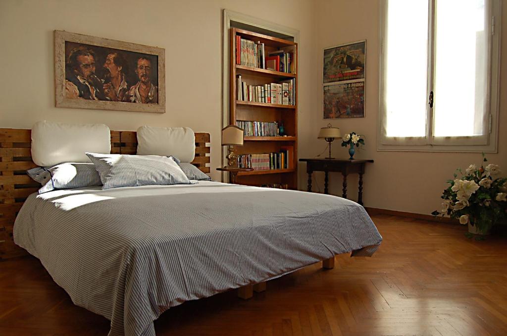 a bedroom with a large bed and a book shelf at Italy Prestigious Guest House in Bologna