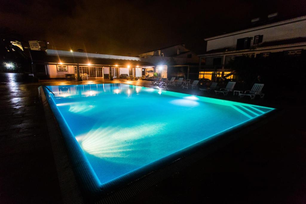 ein großer, nachts beleuchteter Pool in der Unterkunft Casa Barão das Laranjeiras in Ponta Delgada