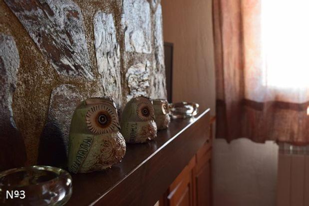 una fila de jarrones sentados en un estante junto a una pared en Los Ayales, en Huelamos