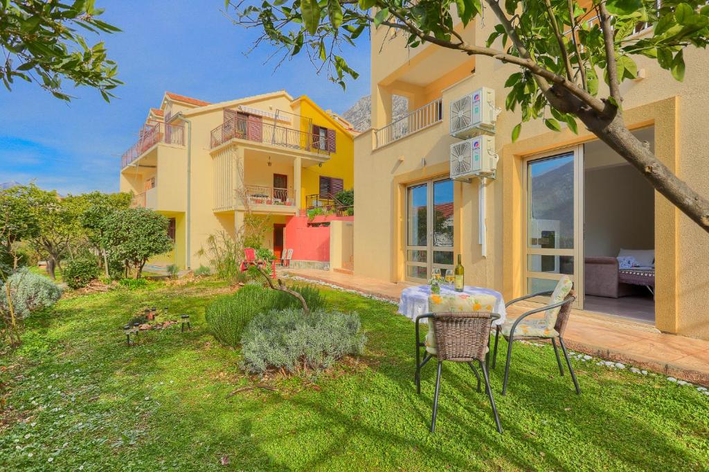 ein Haus mit einem Tisch und Stühlen im Hof in der Unterkunft Apartment Castellino in Kotor