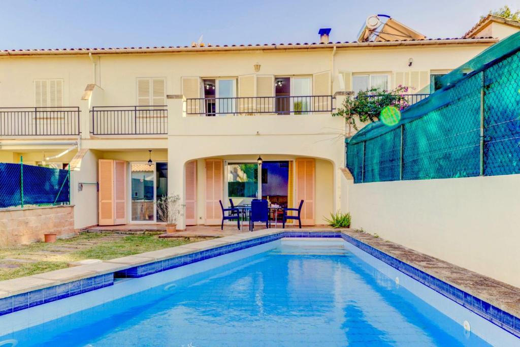 a villa with a swimming pool in front of a house at Beach Villa Can Bauza in Port de Pollensa