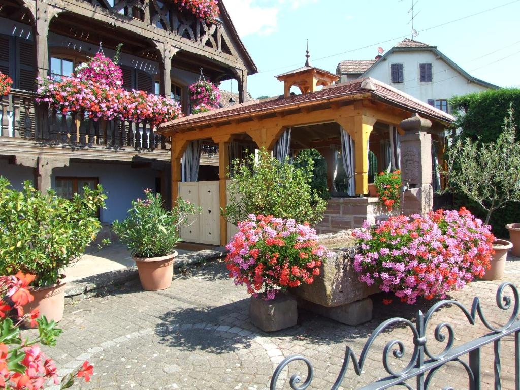 a house with flowers and a sign in front of it at Chambre d&#39;Hôtes &quot;Au Vigneron&quot; in Triembach-au-Val