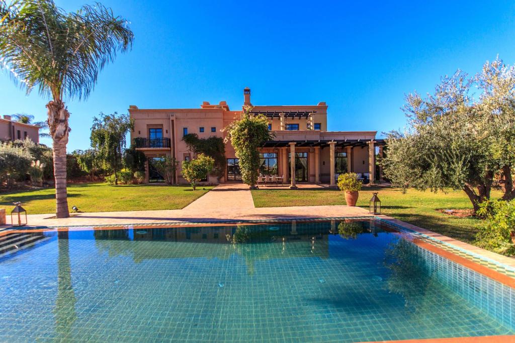 a large swimming pool in front of a house at Villa 69 Samanah Golf Country Club in Ala el Ma
