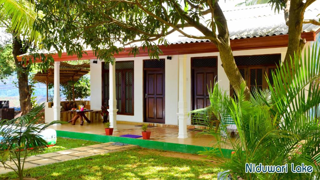 a house in the middle of a garden at Niduwari Lake Homestay in Dambulla