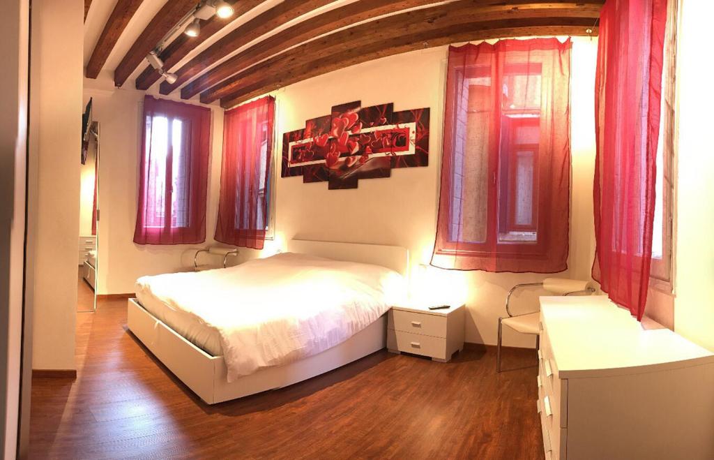 a bedroom with a bed and two windows at Ca' Terlotta in Venice