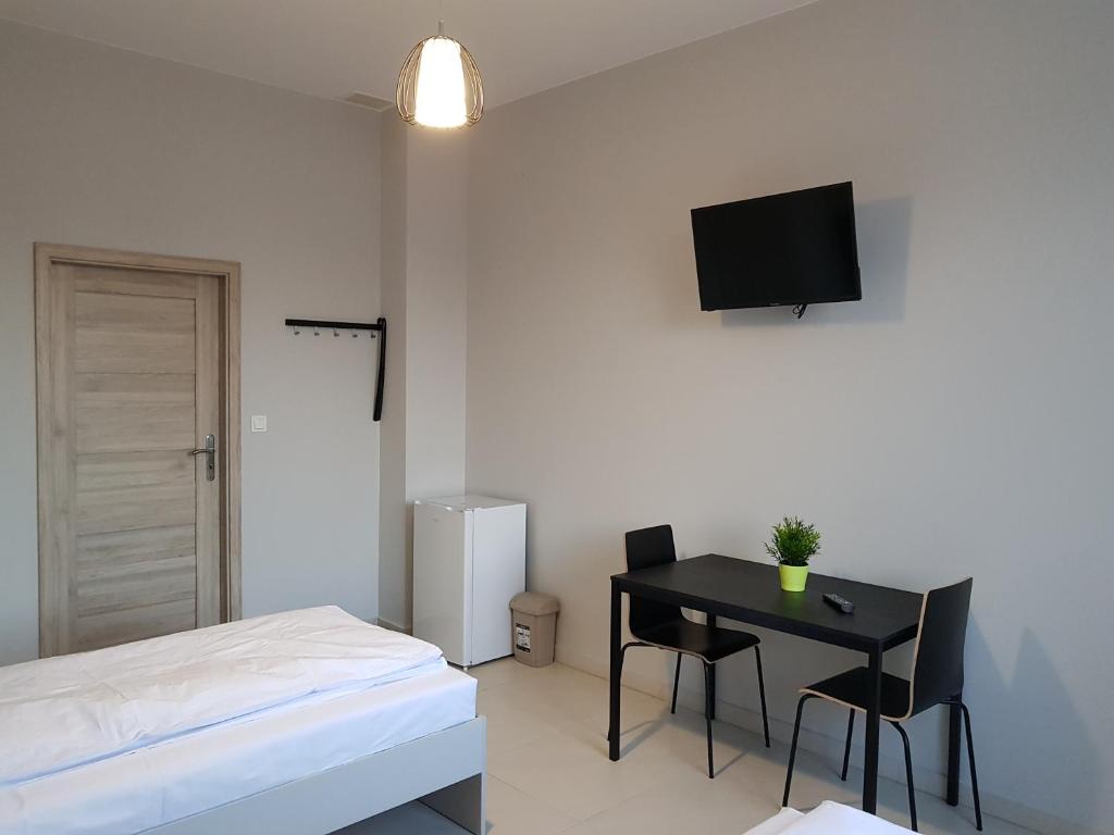 sypialnia z biurkiem, łóżkiem i telewizorem w obiekcie Noclegi MaxTrans w Mielcu