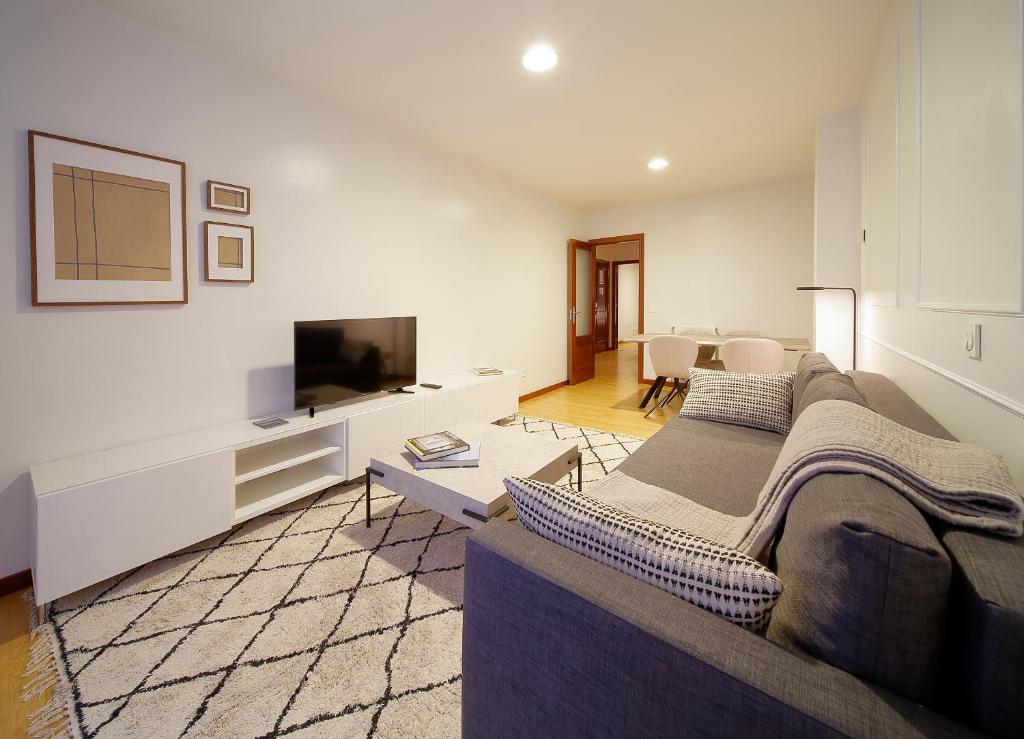 sala de estar con sofá y TV de pantalla plana en Apartamentos Urban Blue, Blue Hotels, en Gijón