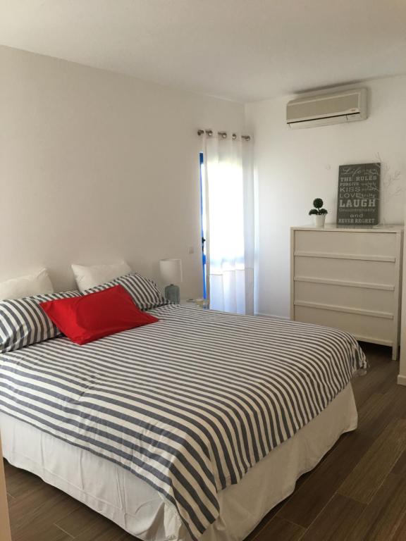 een slaapkamer met een groot bed met een rood kussen bij Apartamento Vilamoura Marina in Vilamoura