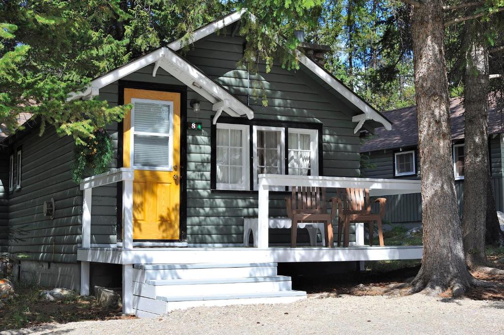 a log cabin with a porch and a yellow door at Tekarra Lodge in Jasper
