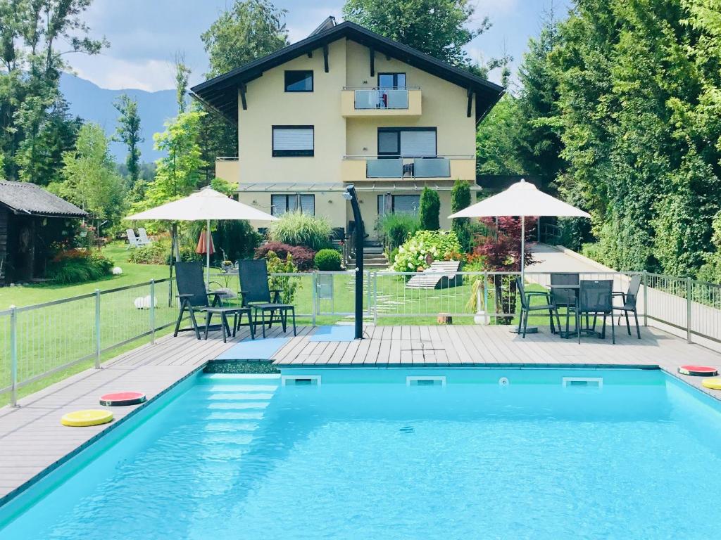 a house with a swimming pool in front of a house at Haus am Wald in Faak am See
