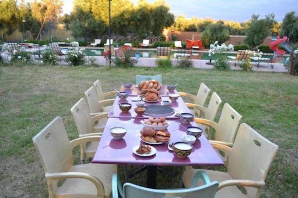 a purple table with food on it with chairs at Atlas Resorts in Aït Ourir