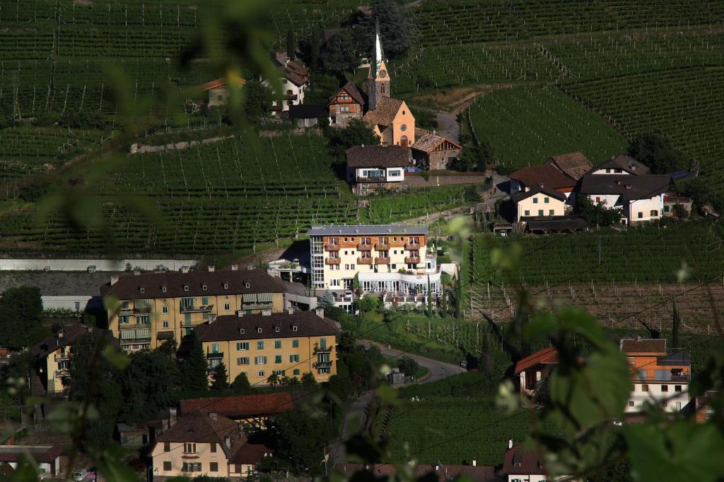 a village in the middle of a hill with a church at Hotel Hanny in Bolzano