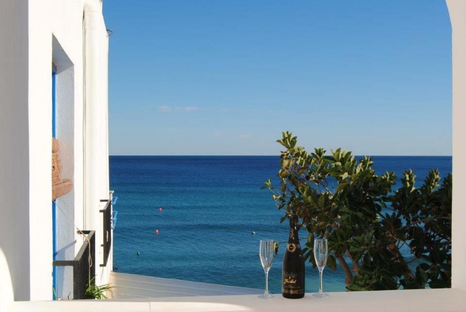 uma vista para o oceano a partir de uma varanda com copos de vinho em EL DUENDE em Las Negras
