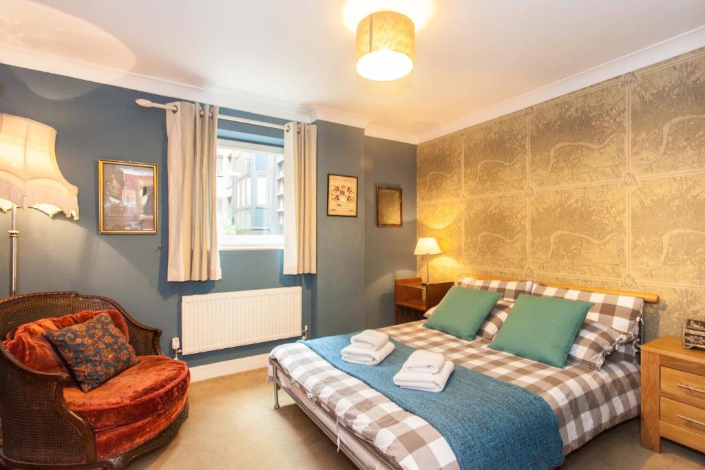 a bedroom with a bed and a chair at Superior 2 Bedroom apartment St Paul's City of London in London