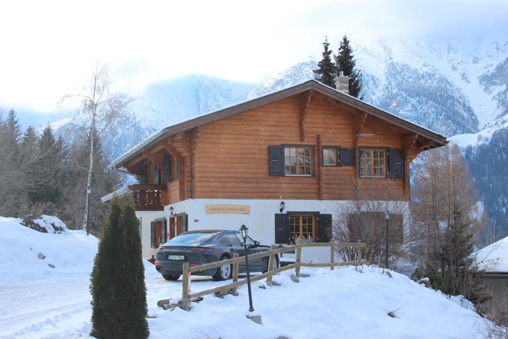 ein Haus mit einem Auto im Schnee in der Unterkunft Chalet Charming in Grächen