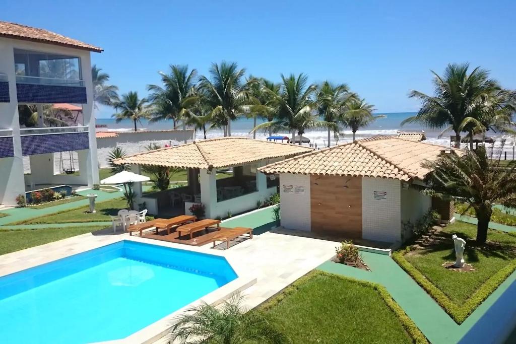 una imagen de una villa con piscina y playa en Triplex em Village - Frente ao Mar, en Ilhéus