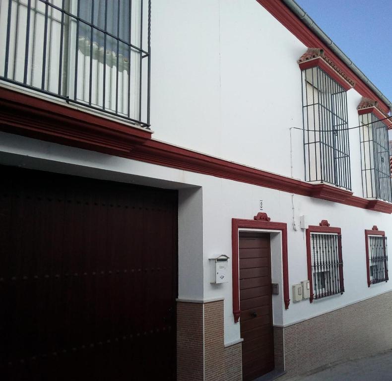 un edificio con garaje y puerta roja en APARTAMENTO EN OLVERA CON GARAJE, en Olvera