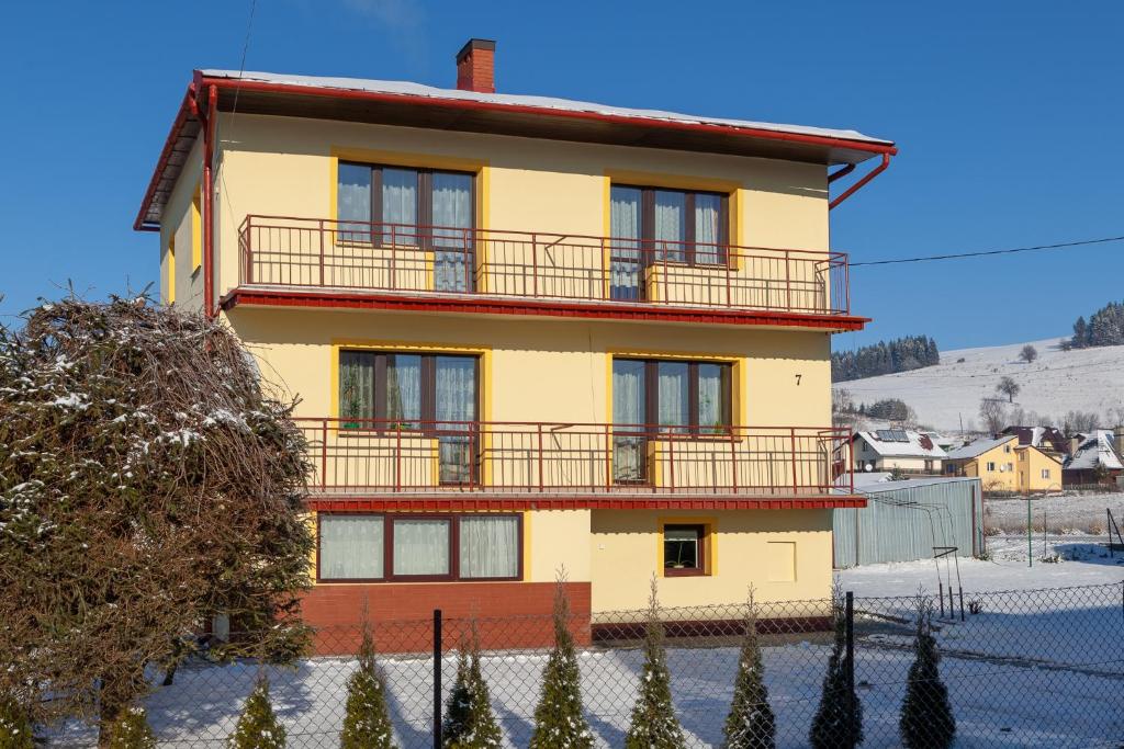 a yellow and red house with a balcony at AGROTURYSTYKA U JURKA in Tylicz
